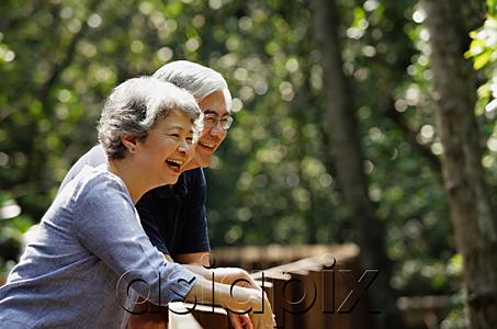 AsiaPix - Mature couple leaning on railing, laughing, looking away