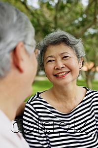 AsiaPix - Mature couple facing each other smiling, woman wearing striped shirt