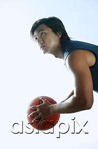 AsiaPix - Man holding basketball, looking up
