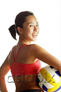 AsiaPix - Woman carrying basketball, looking over shoulder at camera