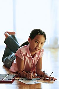 AsiaPix - Girl lying on floor, with paper and crayons, looking at camera