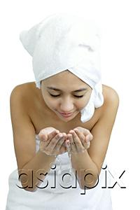 AsiaPix - Woman washing her face, holding water in cupped hands