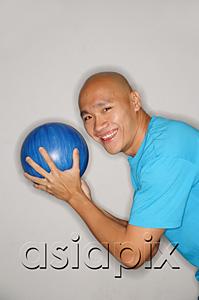 AsiaPix - Man holding bowling ball turning to smile at camera, side view