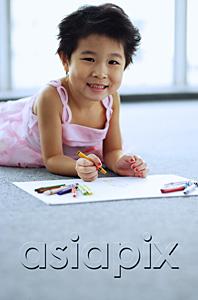 AsiaPix - Young girl lying on floor, holding crayons, smiling at camera