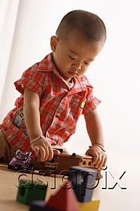 AsiaPix - Young boy playing with toy train