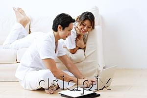 AsiaPix - Couple at home, using laptop