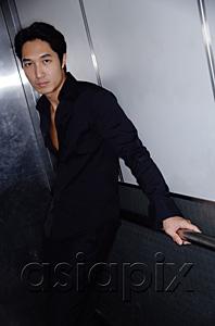 AsiaPix - Man standing, leaning on railing, looking at camera