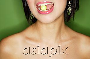 AsiaPix - Woman eating green sweet, cropped image
