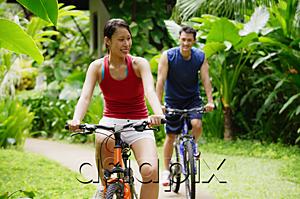 AsiaPix - Couple cycling through a park