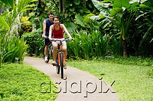 AsiaPix - Couple cycling leisurely through a park