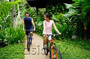 AsiaPix - Couple cycling on a path through a park