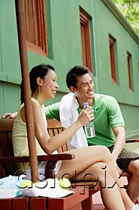 AsiaPix - Couple in tennis outfit, sitting on bench on tennis court
