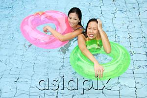 AsiaPix - Women in swimming pool, holding inflatable ring, looking at camera