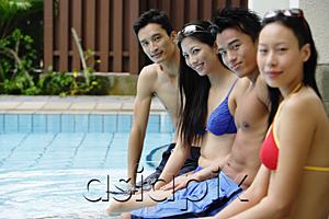 AsiaPix - Young adult couples sitting at edge of swimming pool, side view