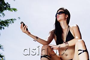 AsiaPix - Woman in bikini, holding mobile phone