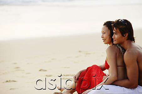 AsiaPix - Couple sitting on beach, embracing,  looking at sea