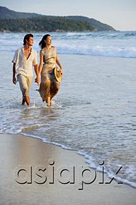 AsiaPix - Couple walking on beach, looking away