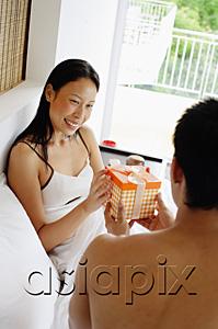 AsiaPix - Couple in bed, man giving woman a gift
