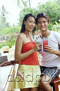 AsiaPix - Couple at beach bar, holding drinks, looking at camera