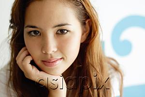 AsiaPix - Young woman looking at camera, hand on chin