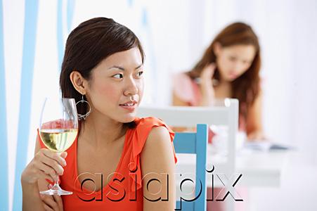 AsiaPix - Woman in cafe, holding wine glass, looking away