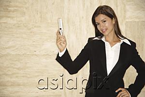 AsiaPix - Businesswoman with mobile phone, looking at camera, hand on hip
