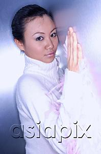 AsiaPix - Young woman in white turtleneck leaning on wall