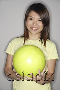 AsiaPix - Woman holding yellow bowling ball, smiling at camera