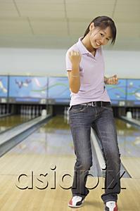 AsiaPix - Woman at bowling alley, smiling, making a fist