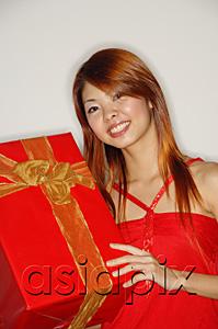 AsiaPix - Woman holding red gift box, smiling