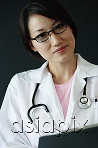 AsiaPix - Female doctor holding clipboard, looking at camera