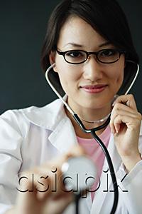 AsiaPix - Female doctor using stethoscope