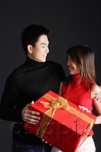 AsiaPix - Couple holding gift, looking at each other