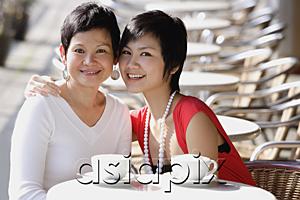 AsiaPix - Mother and adult daughter in cafe, smiling at camera