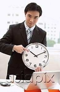 AsiaPix - Businessman holding and pointing at clock