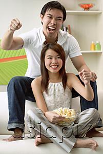 AsiaPix - Couple in living room, man sitting on sofa, woman on floor