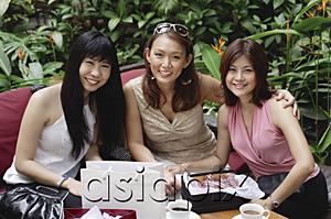 AsiaPix - Three women at outdoor garden cafe, sitting side by side, smiling at camera