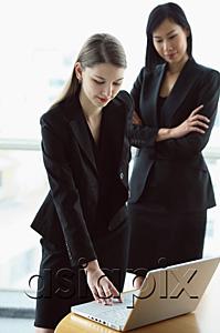 AsiaPix - Two women standing in front of laptop