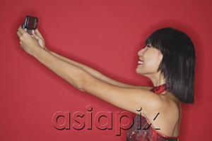 AsiaPix - Woman using mobile phone to take a picture of herself