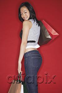 AsiaPix - Woman carrying shopping bags, looking over shoulder