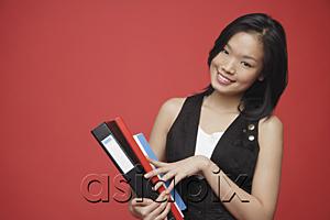 AsiaPix - Woman carrying books, looking at camera, smiling