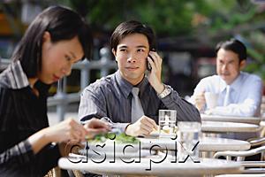 AsiaPix - Business people at outdoor cafÃ©, focus on man with mobile phone