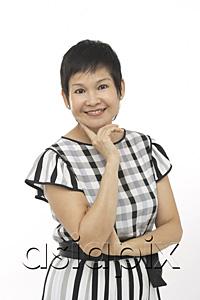 AsiaPix - Mature woman against white background, hand on chin, smiling at camera