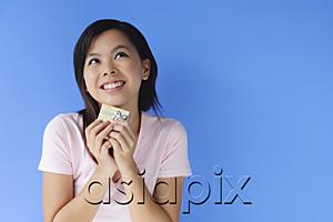 AsiaPix - Young woman holding small gift box, looking away