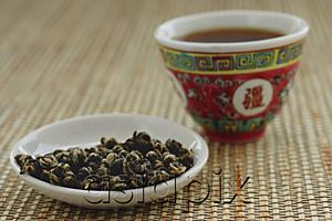 AsiaPix - Tea leaves on plate with Chinese teacup