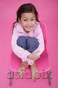 AsiaPix - Girl sitting on chair, hugging knees, smiling up at camera