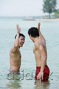 AsiaPix - Two men standing in sea, giving high fives