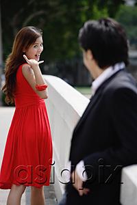 AsiaPix - Woman making hand sign to man in foreground