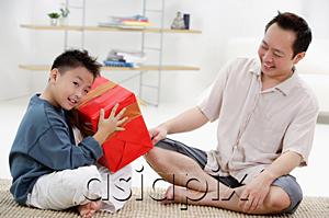 AsiaPix - Father and son at home, boy holding big gift box