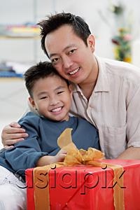AsiaPix - Father and son next to gift box, looking at camera